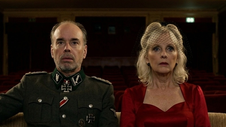 The two of them in costume, seen from the screen looking back